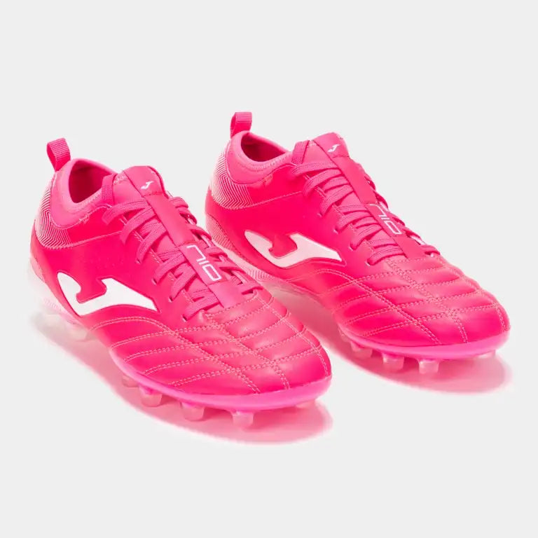 A pair of pink Joma Numero-10 Top football cleats for firm ground, featuring a synthetic leather upper and a translucent sole.