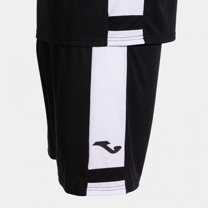 Black and white sports shorts with a brand logo on a light gray background