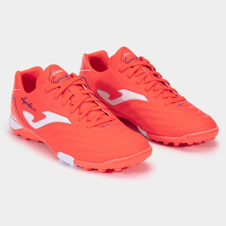 Pair of bright orange soccer shoes with white accents on a light gray background